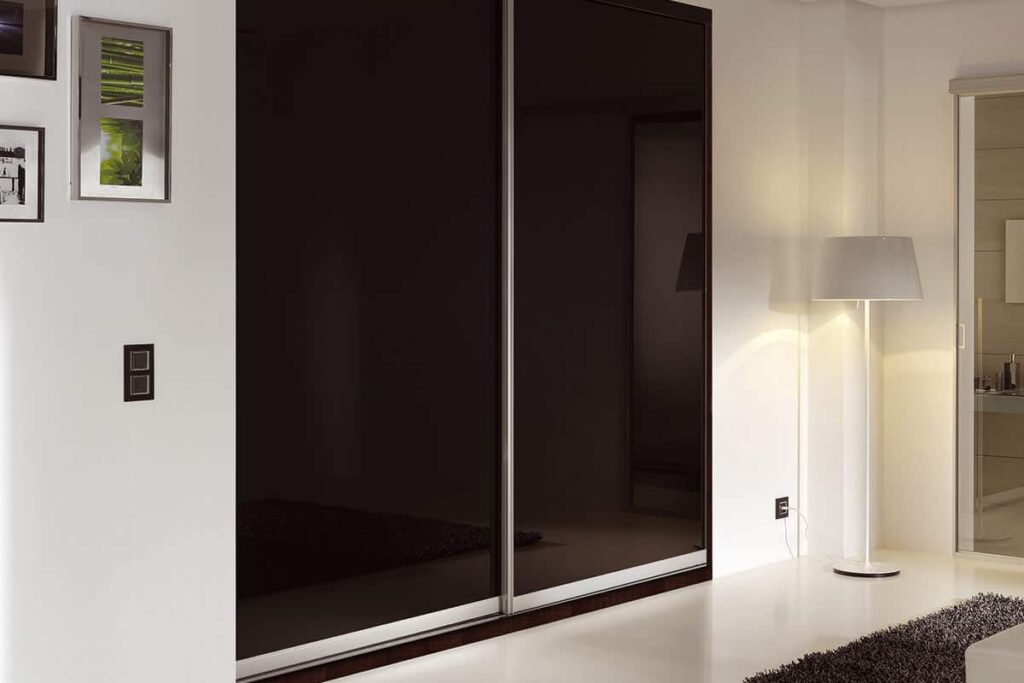 Minimal wardrobes with sliding doors in a room.