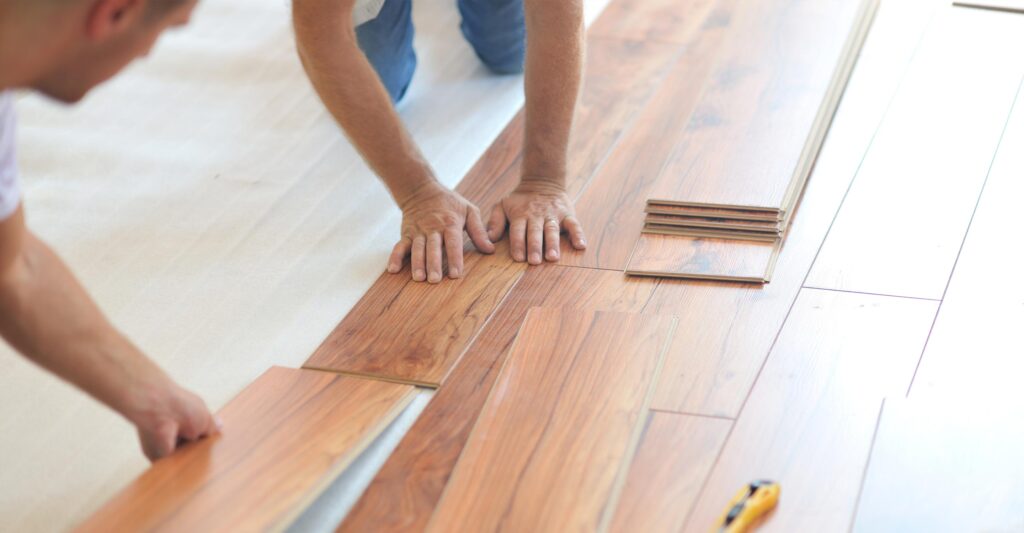 Men applying flooring laminate to the floor
