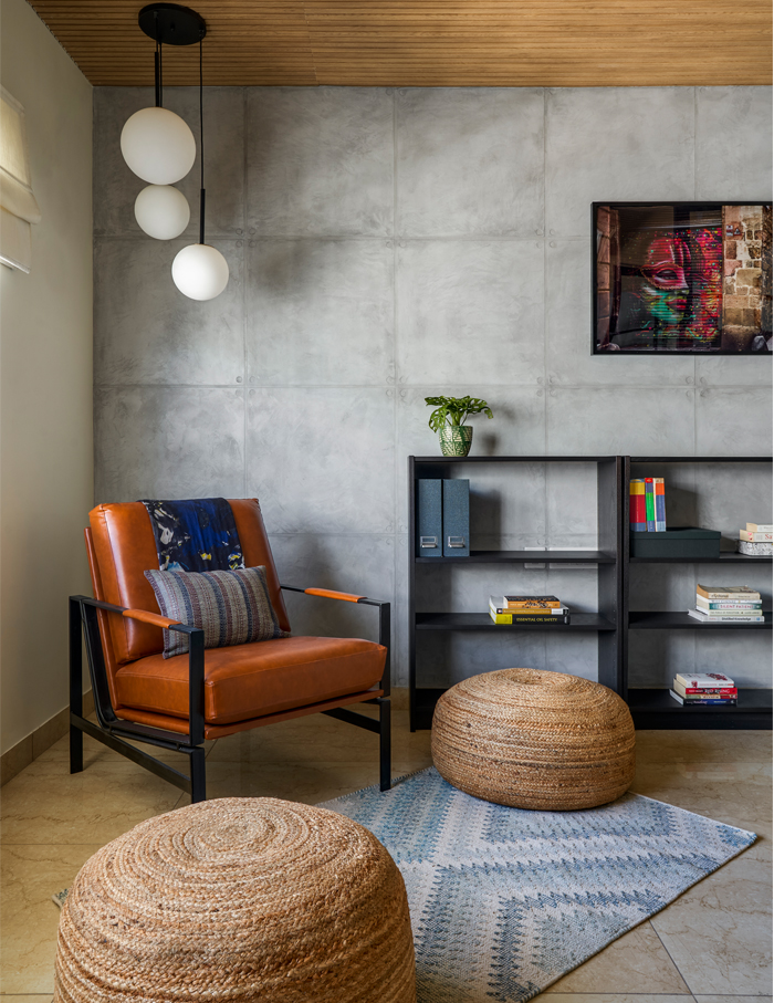 

Exposed black-framed accent chair (industrial style) against a concrete finish backdrop showcases an industrial style interior design.